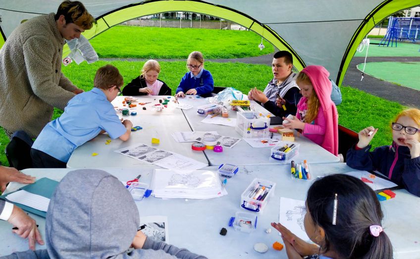 young children doing arts and crafts under a gazebo