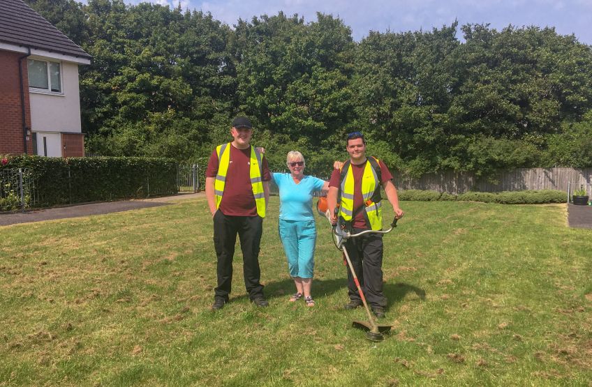 Wheatley Homes Glasgow customer Marion standing with two staff from NETs