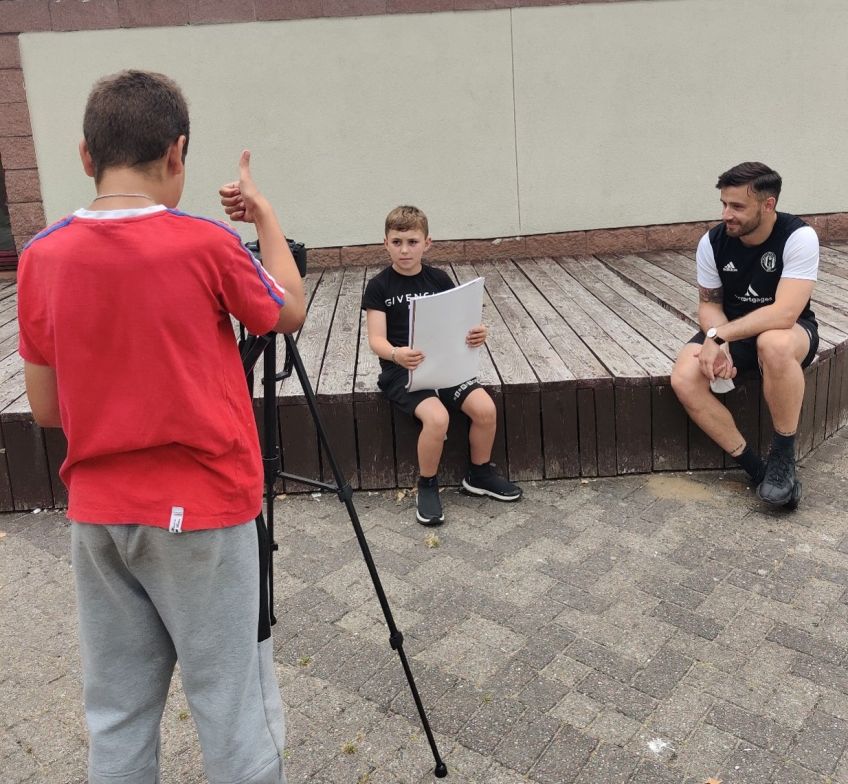 Three boys learn to film and present during workshops